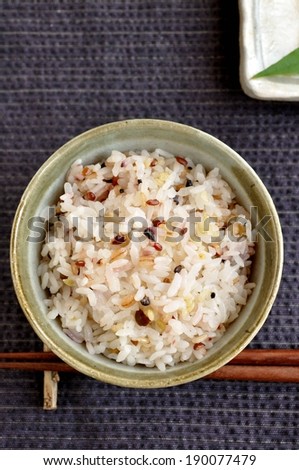 A small bowl of steaming hot rice with seasoning.