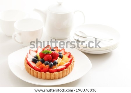 A fruit tart served on a white plate.