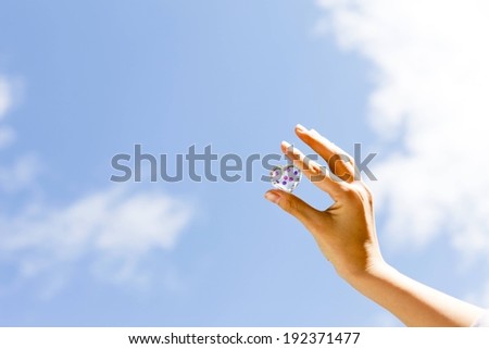 A person holding a small heart shaped object in their right hand