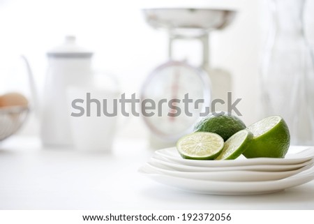A lime cut in half along side smaller slices sit on a serving dish.