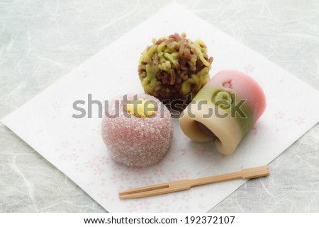 Three small food items sit on a paper towel next to chopsticks.
