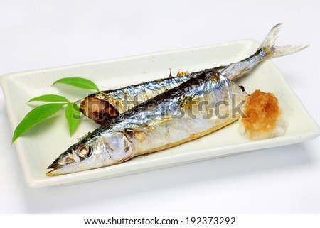 Two cooked fish served on a white plate.