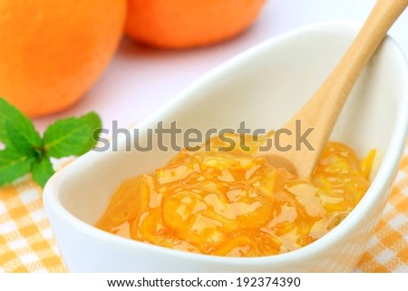 A dish of mango jelly and a spoon.