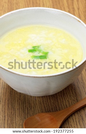 A dish of yellow and white soup, with a green garnish.
