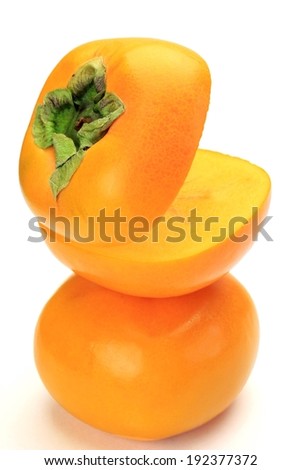 A tower of round orange fruit with the top one cut open.