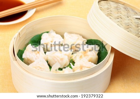 A bowl with some green leaves and food on top.