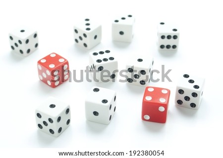 Nine white dice, and two red dice on a white surface.