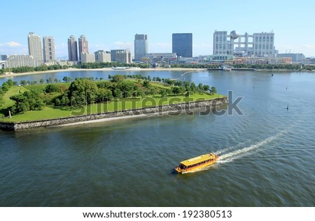 A ferry in a body of water in front of a city.