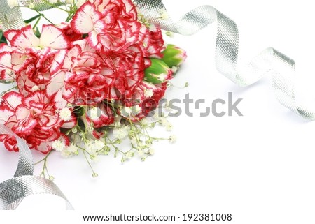 A bunch of red and white flowers with silver ribbon.