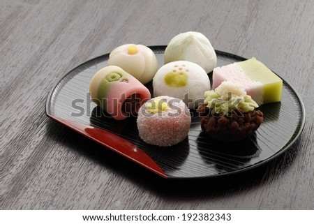 Seven food items arranged on a black tray.