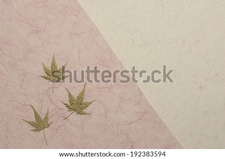 Three green colored leaves on top of neutral colored parchment.