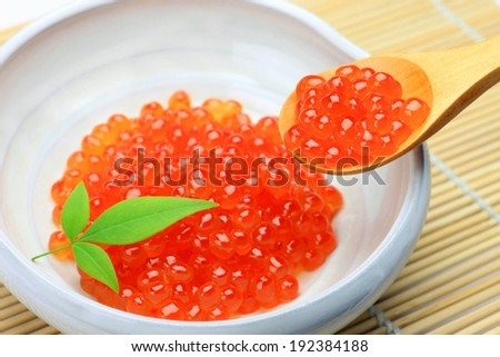 A bunch of orange food type beads in a white bowl.
