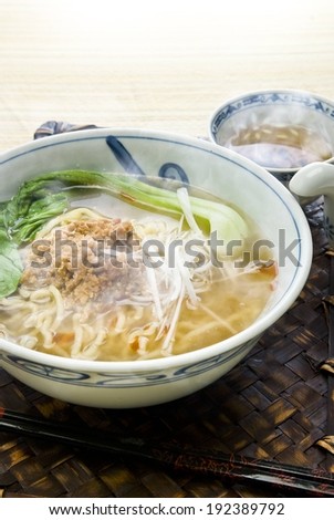 A bowl of steaming hot soup with onions.