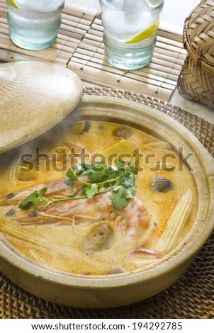A steaming bowl of shrimp, vegetables and broth.