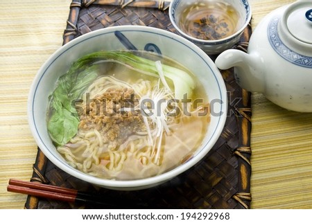 A steaming dish of noodles and vegetables in broth.