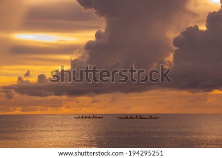 Two row boats in open water at sunrise over a cloudy sky.