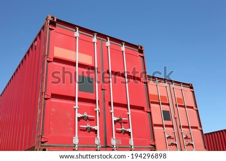 Three big red storage trailers with locks on them.
