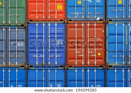 Three vertical rows of shipping containers that are different colors.