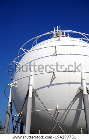 A large ball shaped storage tank with metal rods going around it.