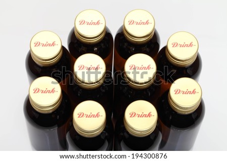 Ten bottles grouped together with identical bottle caps.
