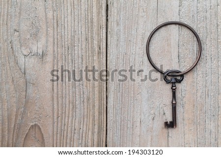 A key ring holding a vintage black and gold key.