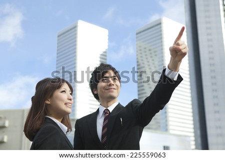 Businesswoman and Businessman are Pointing at the sky