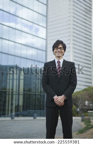 Business man is standing in front of the building