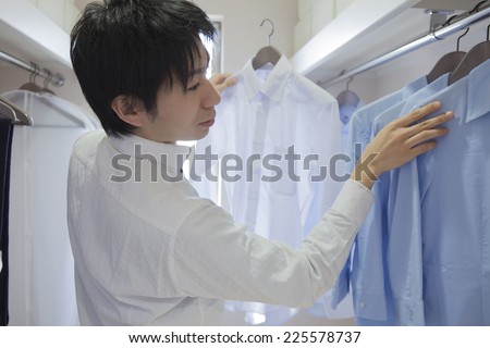 Man choosing the shirt in the closet