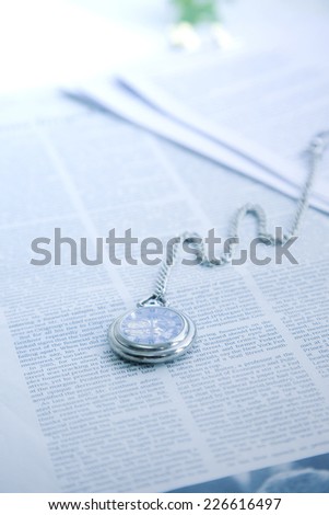 English-language newspapers and a pocket watch