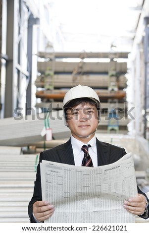 Japanese man reading a newspaper in a warehouse