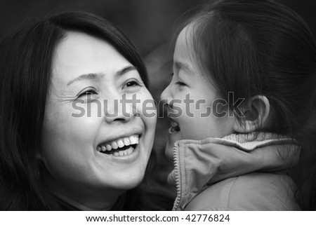 mother and 8-year old daughter in park, laughing, shanghai, china