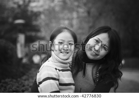 mother and 8-year old daughter in park, shanghai, china