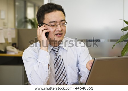 asian business executive making a phone call in office