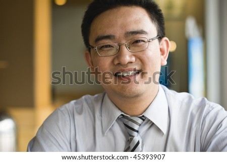 portrait of smiling asian business executive sitting in office
