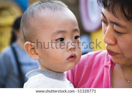 young asian mother looking at her 2-year old son.