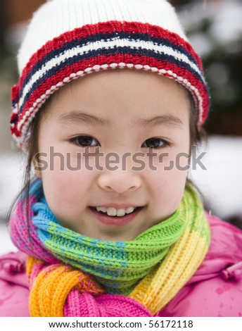 outdoor portrait of a 9-year old asian girl in colorful winter outfits