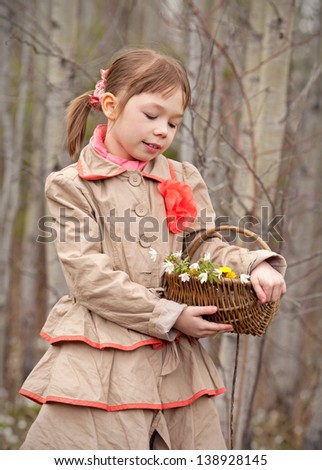 Beautiful girl with a basket of flowers in their hands