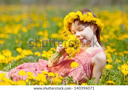 Charming girl enjoys the scent of flowers