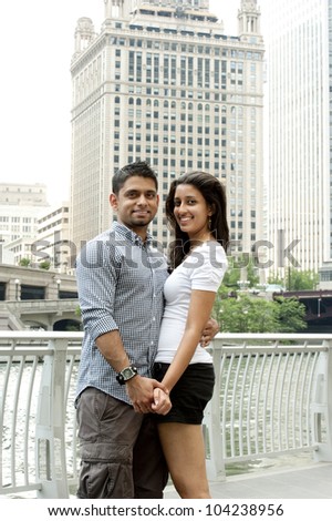 A happy young Indian couple with a Chicago Skyline.