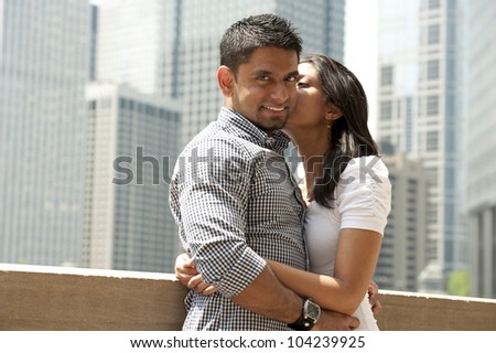 A happy Indian couple with a Chicago skyline in the background.
