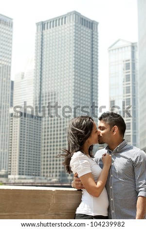 A happy Indian couple with a Chicago skyline in the background.