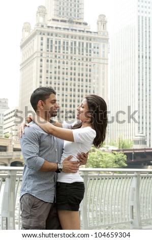 A happy young Indian couple with a Chicago Skyline.