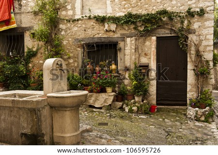 A water fountain near a door entrance to medieval home in Saint-Paul-de-Vence.