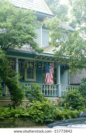 The flag draped veranda of a blue country house in the summer.