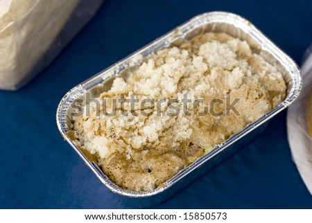 Strudel topped coffee cake for sale on a blue tablecloth.