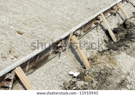 Wooden beams supporting cement on a construction site.