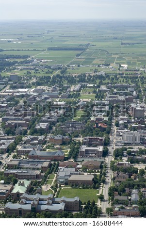 An aerial span of a university campus and the green plains behind it.