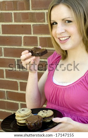 Shot of young female holding a plate of cookies and brownies
