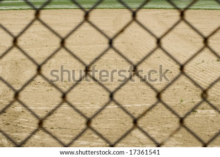 View of empty baseball field through a metal fence