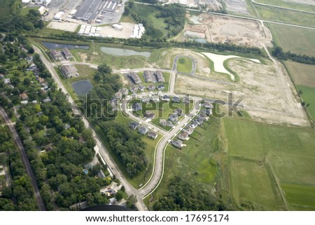 Overhead view of a green field of trees and homes